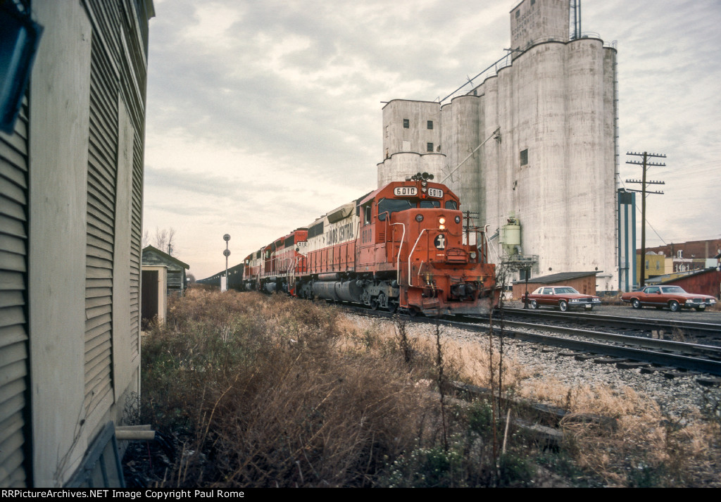 IC 6010 SD40A and GMO 910 SD40 lead another IC SD40A with a coal train past the Tuscola Coop Grain elevator